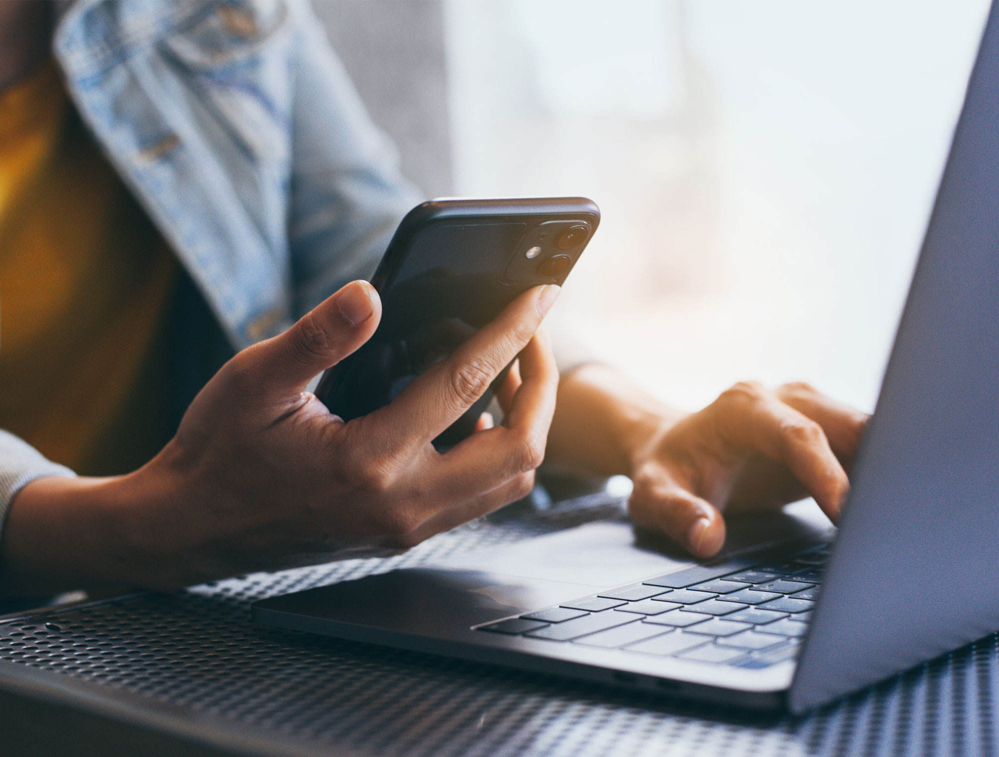 Kontakt & Anmeldung bei PVP Triptis | Reifenanlieferung und Service Person nutzt Smartphone und Laptop zur Kontaktaufnahme und Anmeldung bei PVP Triptis